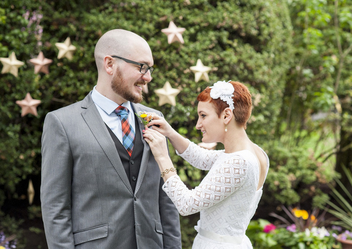 bride pinning boutonniere on groom