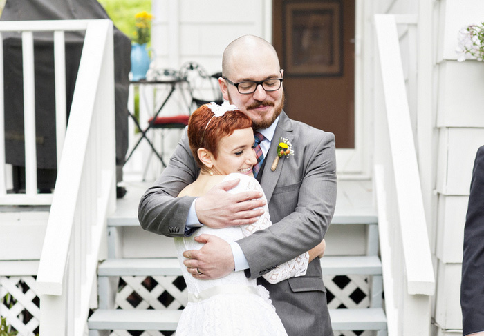 bride and groom hugging in backyard