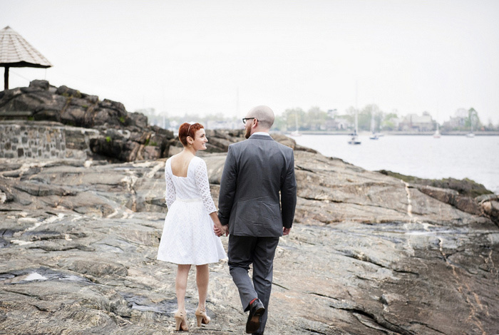 bride and groom walking by the water