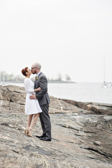 bride and groom kissing by the water