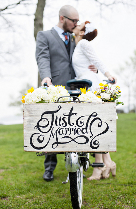 couple kissing behind just married sign