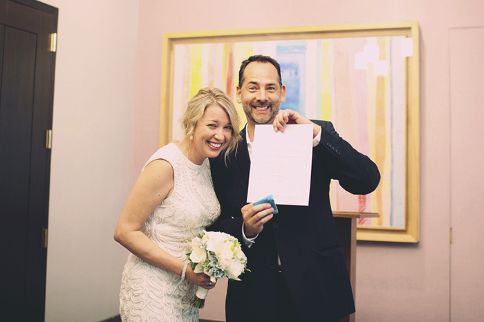 bride and groom with marriage certificate