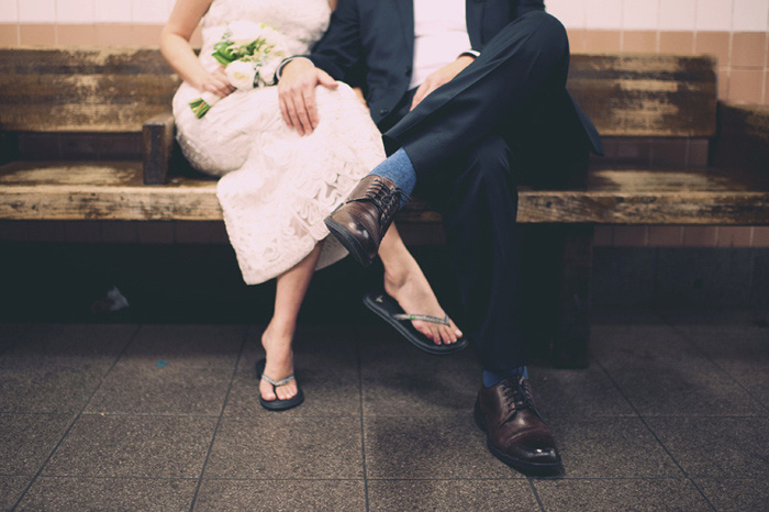 bride and groom sitting on subway bench