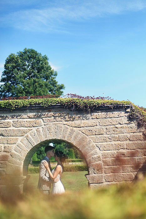 bride and groom under brick archway