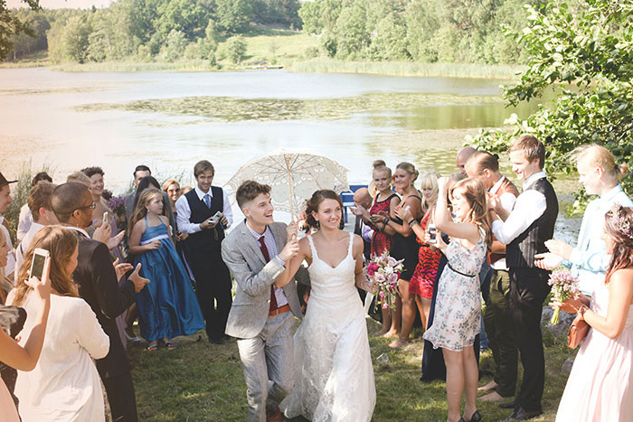 bride and groom walking through crowd of guests