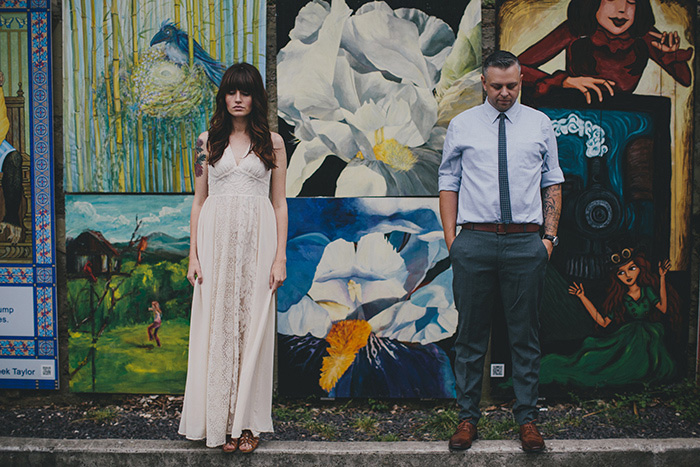 bride and groom in front of mural