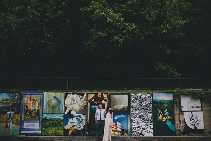 bride and groom in front of mural