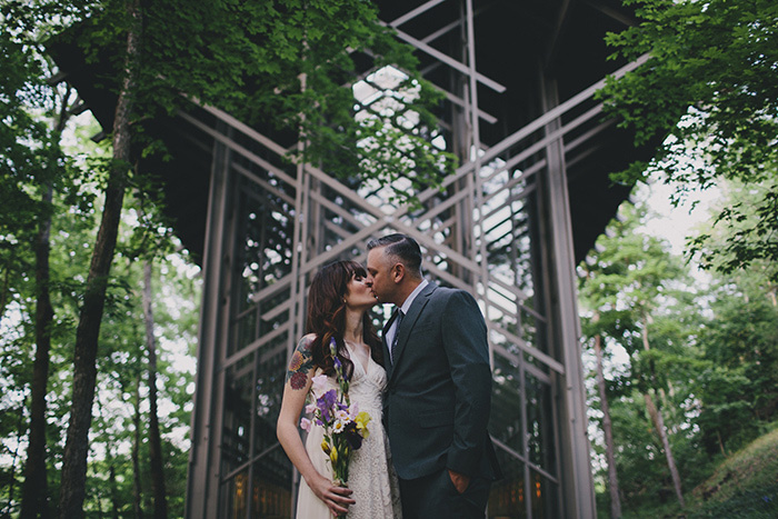 bride and groom kissing in front of chapel