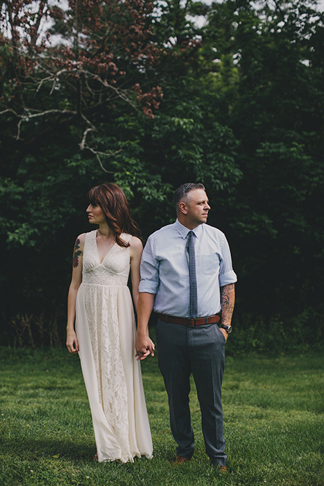 bride and groom holding hands and looking away