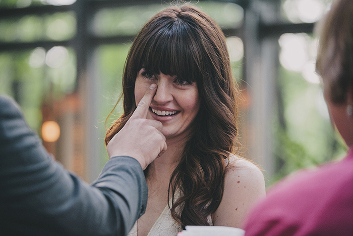 groom wiping away bride's tears