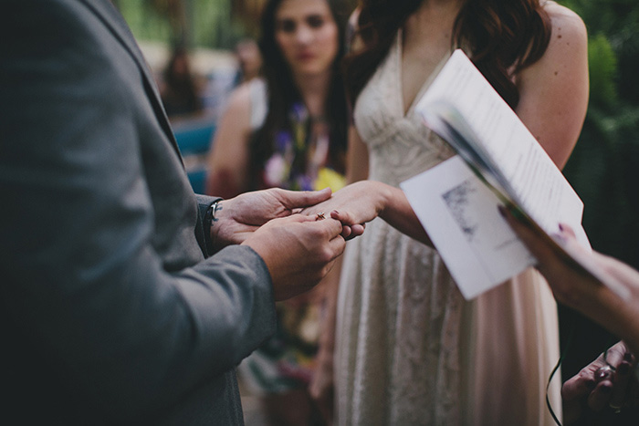 groom putting ring on bride's finger