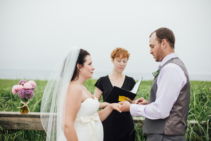 groom putting ring on bride's finger