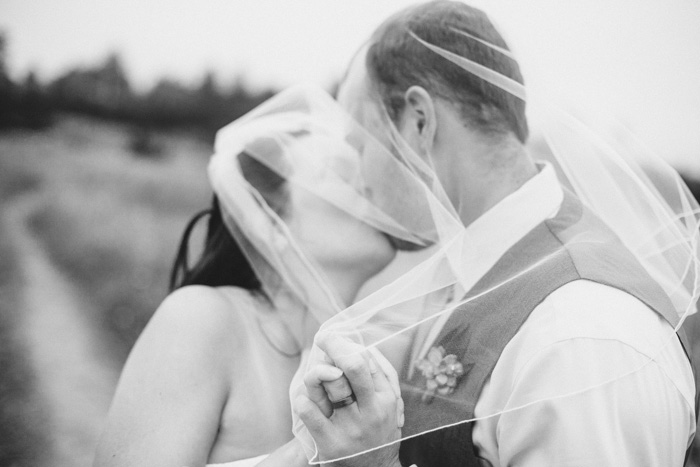 bride and groom kissing under veil