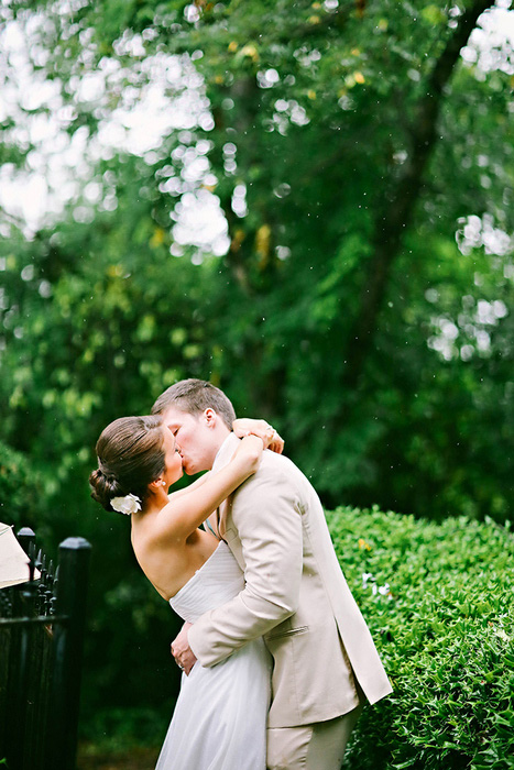 bride and groom kissing in the rain