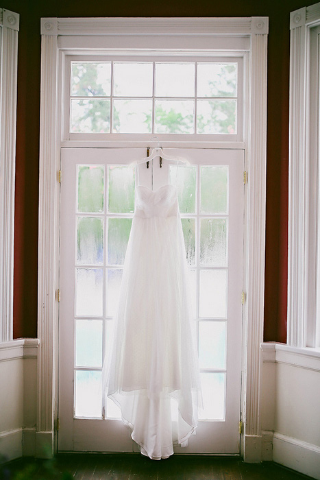 wedding dress hanging in doorway