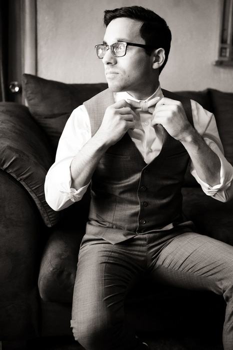 groom adjusting bow tie