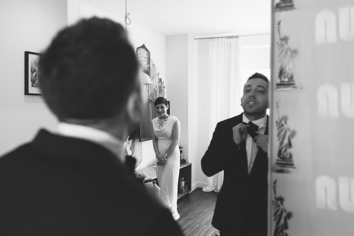 groom tying bow tie