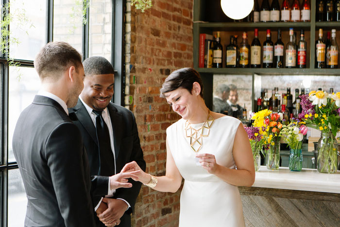 bride putting ring on groom's finger