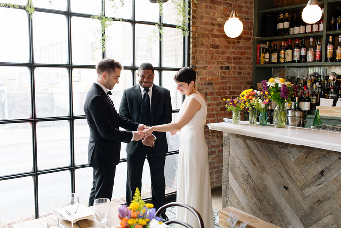 groom putting ring on bride's finger