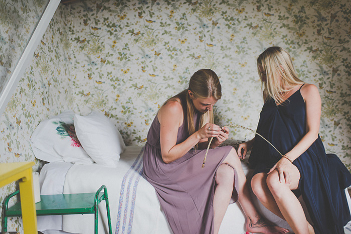 friend helping bride with headband