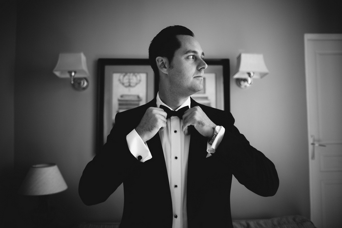 groom adjusting bow tie