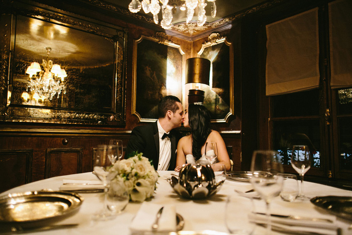 brideand groom kissing in Paris restautrant