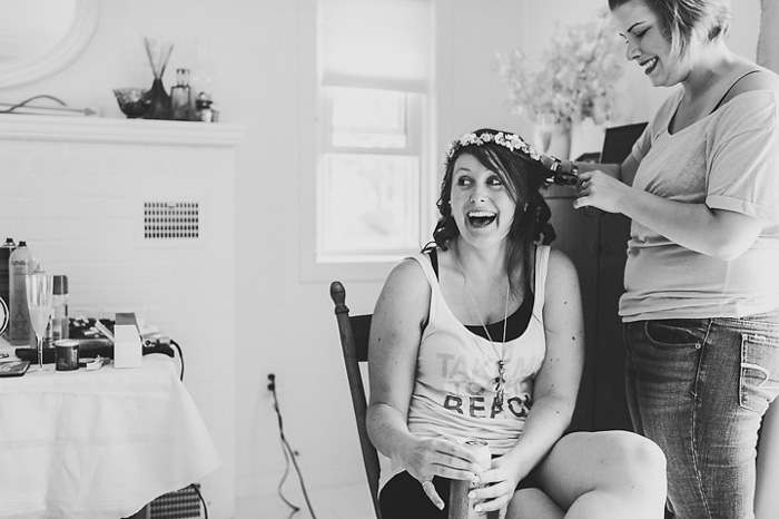 bride laughing while getting her hair done