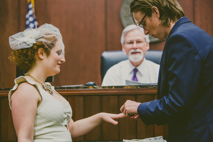 groom putting ring on bride's finger