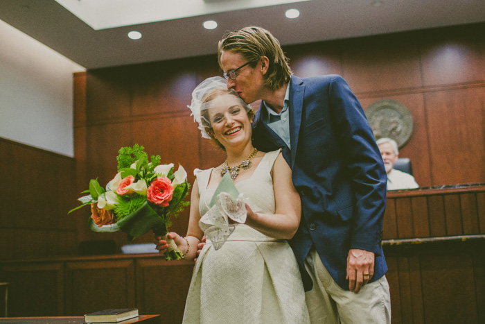 groom kissing bride at courthouse