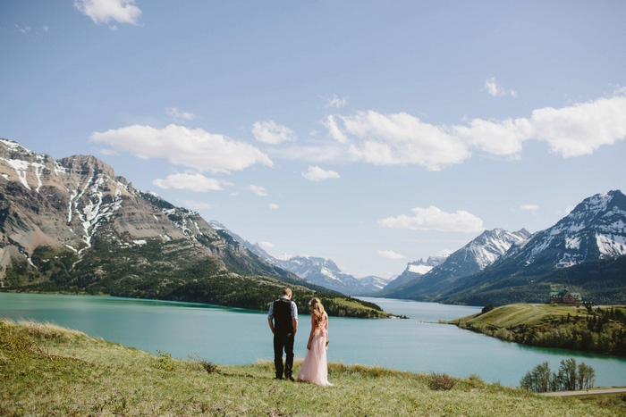 bride and groom by lake and mountains