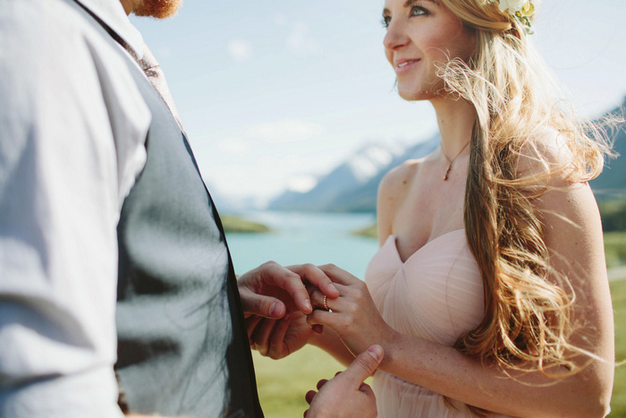 groom putting ring on bride's finger