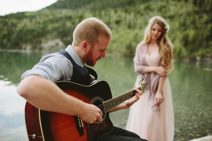 bride watching groom play guitar