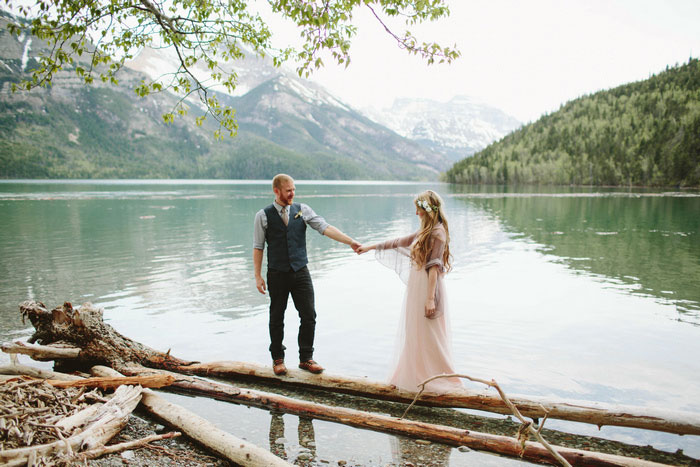 bride and groom walking across logs