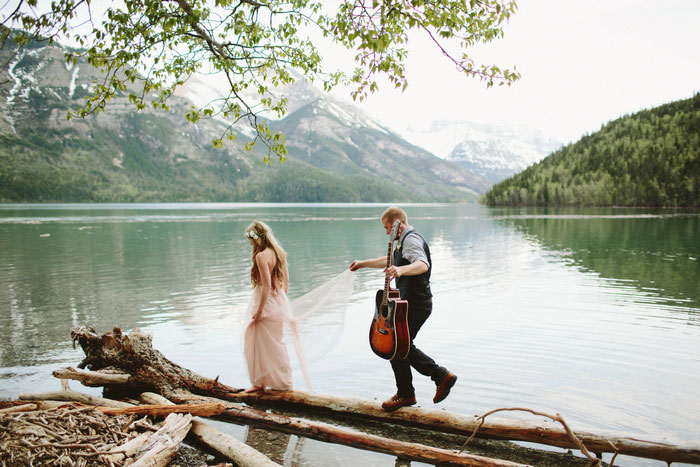 bride and groom walking across logs
