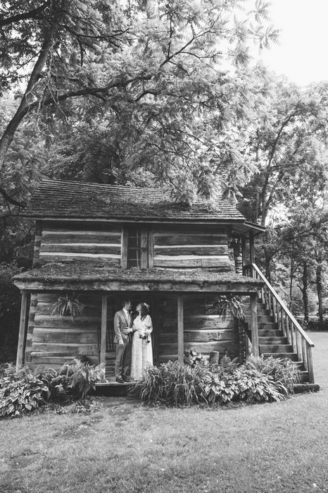 bride and groom standing on cabin porch