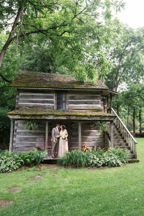 bride and groom kissing on cabin porch