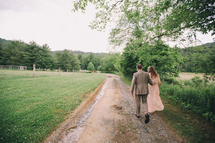 bride and groom walking down dirt road