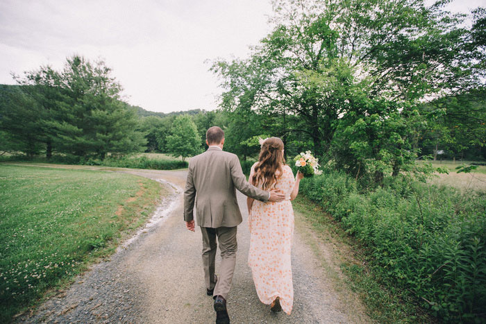 bride and groom walking down dirt road