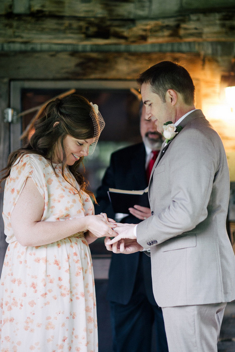 bride putting ring on groom's finger