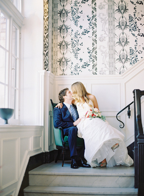 bride and groom kissing in chair