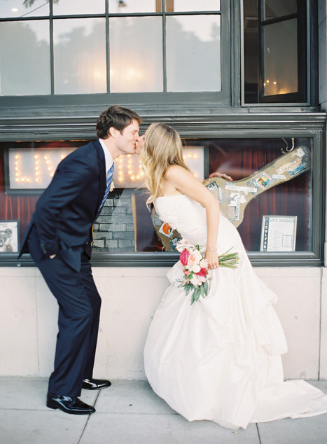 bride and groom kissing on the street