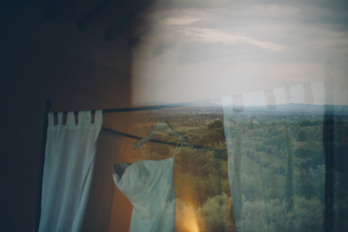 wedding dress hanging on bed