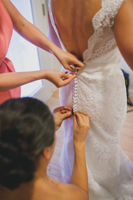 bride getting her dress buttoned up