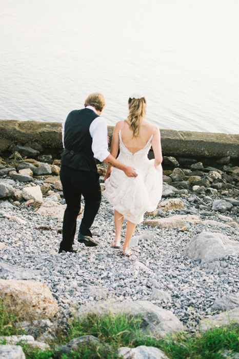 bride and groom walking down to the water