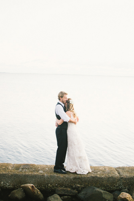 bride and groom hugging by the ocean