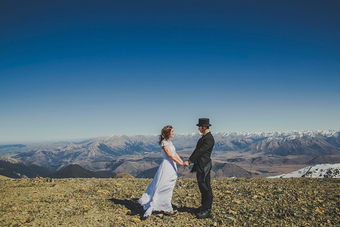 bride and groom holding hands onmountain