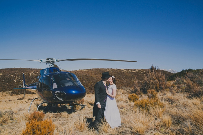 bride and groom kissing by helicopter