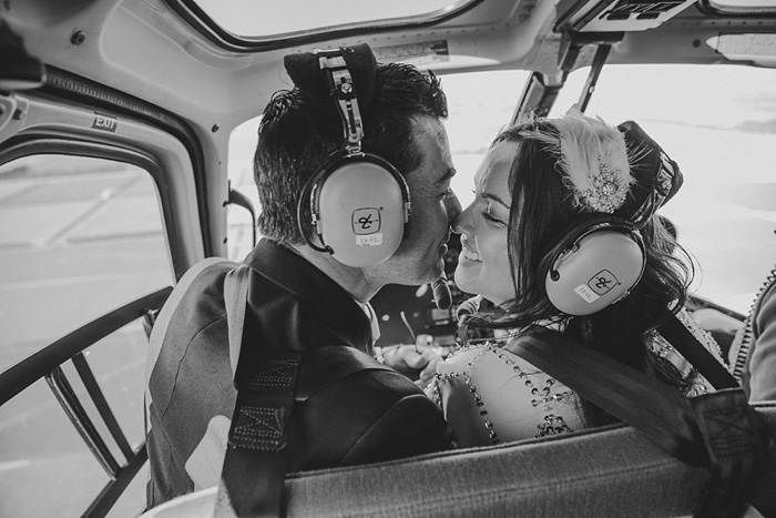 bride and groom kissing in helicopter