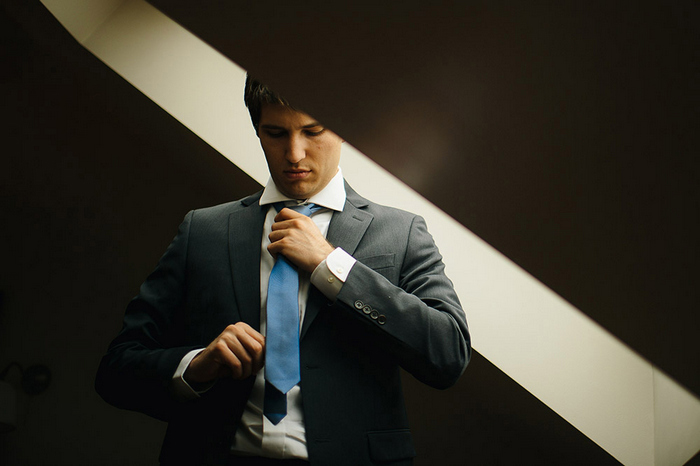 groom adjusting tie