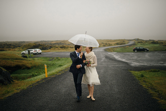 bride and groom walking under umbrella